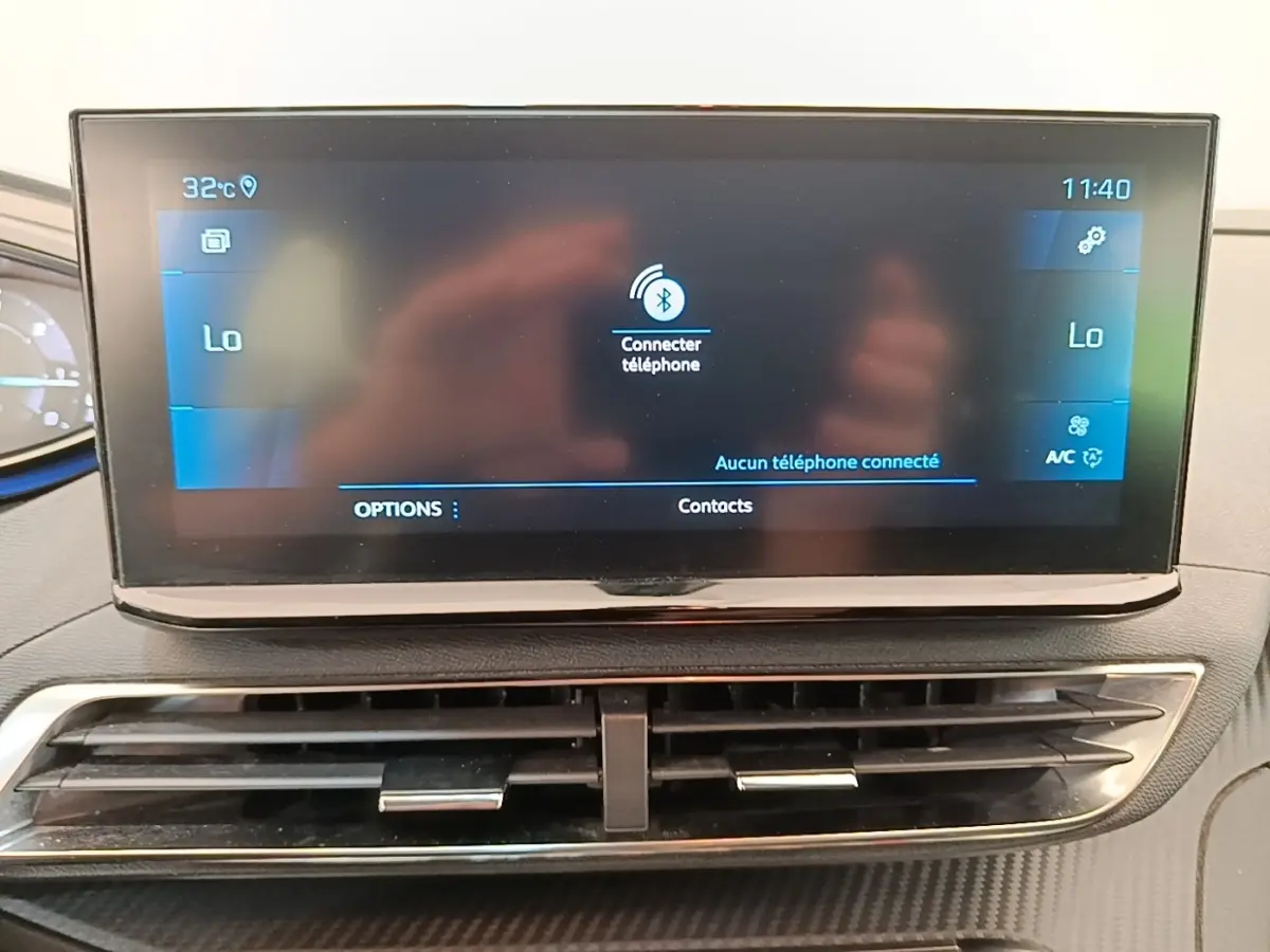 Écran tactile central du tableau de bord du Peugeot 3008 2022, affichant la connexion Bluetooth, avec aérateurs en dessous.