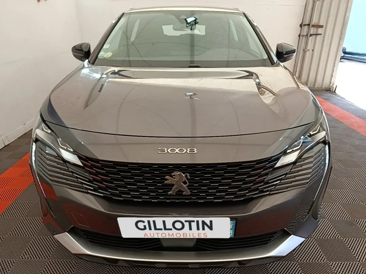 Vue frontale d’un Peugeot 3008 gris foncé avec calandre noire et phares LED distinctifs.