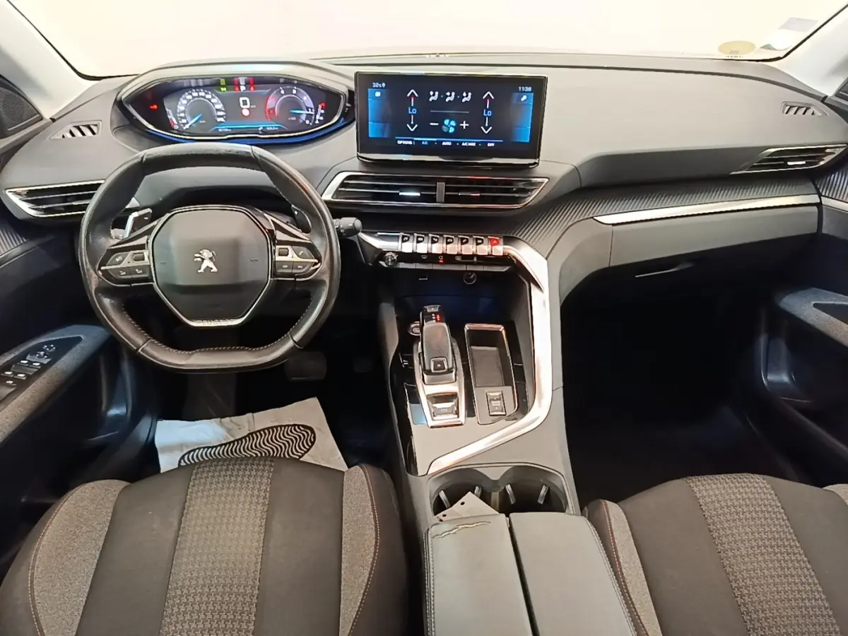 Vue intérieure avant du Peugeot 3008 2022, tableau de bord moderne avec écran tactile et volant cuir multifonctions.