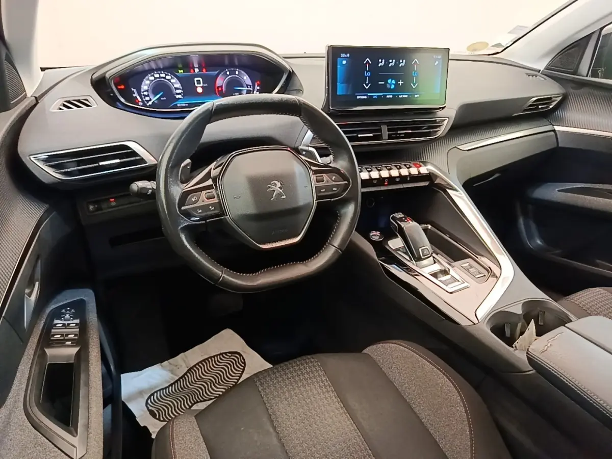 Vue intérieure avant du Peugeot 3008 2022, volant cuir multifonctions et écran tactile central lumineux.