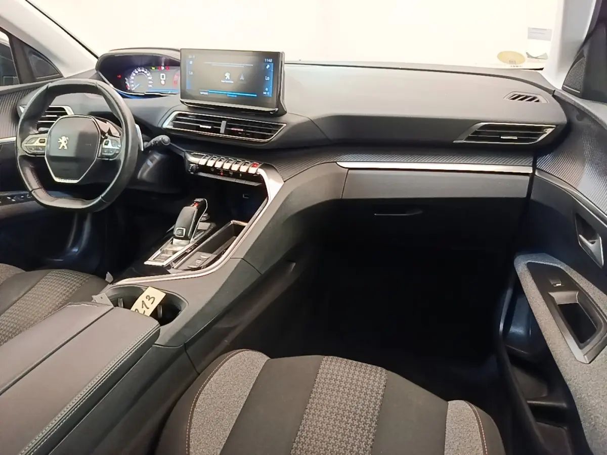 Vue intérieure côté conducteur du Peugeot 3008 gris foncé 2022, avec volant cuir multifonctions et écran tactile central.