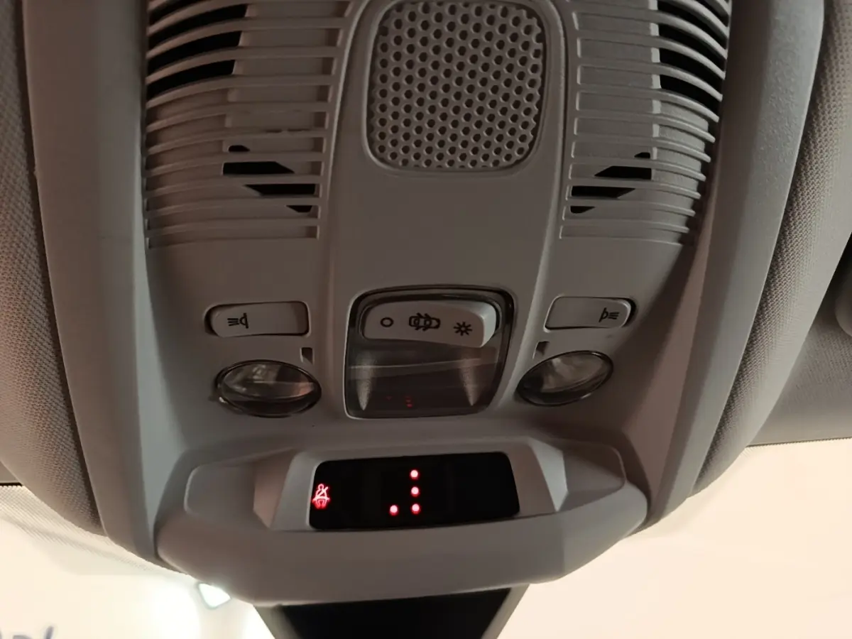 Vue en gros plan du plafonnier gris clair avec commandes d’éclairage et indicateur de ceinture allumée dans un Peugeot 3008 gris foncé.