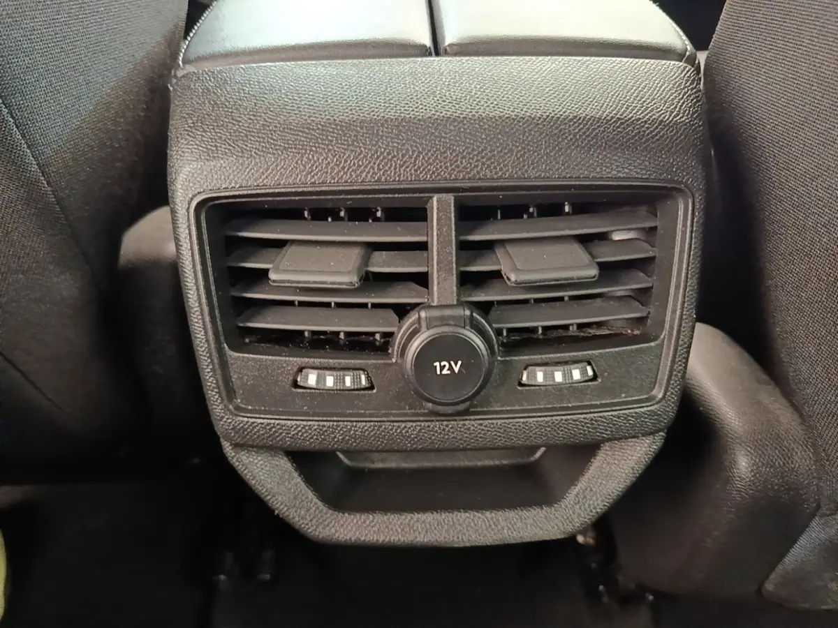 Gros plan sur la sortie d’air arrière noire avec prise 12V du Peugeot 3008 gris foncé, vue intérieure centrale.