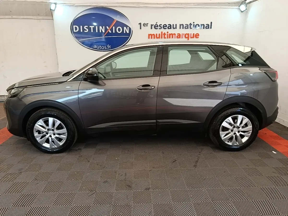 Vue de profil côté gauche d’un Peugeot 3008 gris foncé 2022, avec jantes alliage et rétroviseurs ton caisse.
