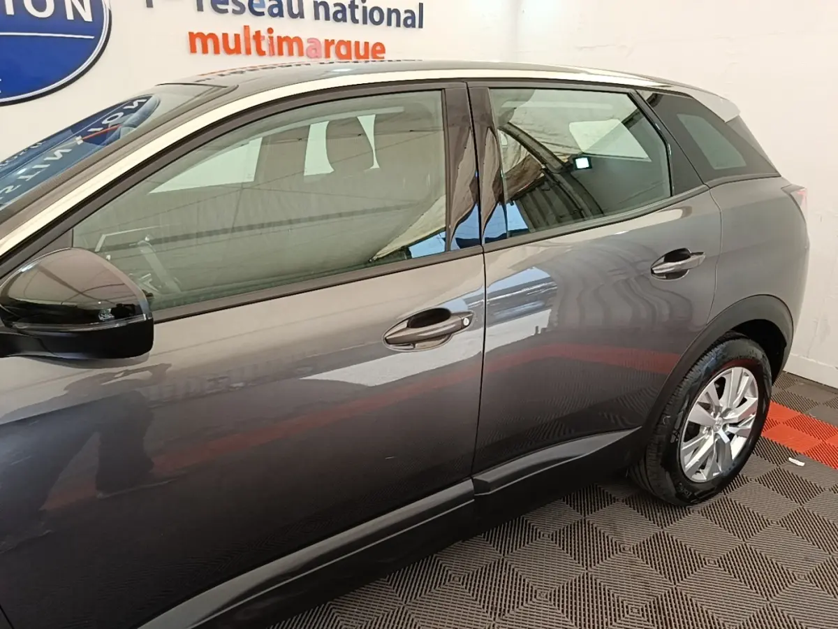 Vue latérale droite d'un Peugeot 3008 gris foncé avec rétroviseurs noirs et jantes alliage visibles.