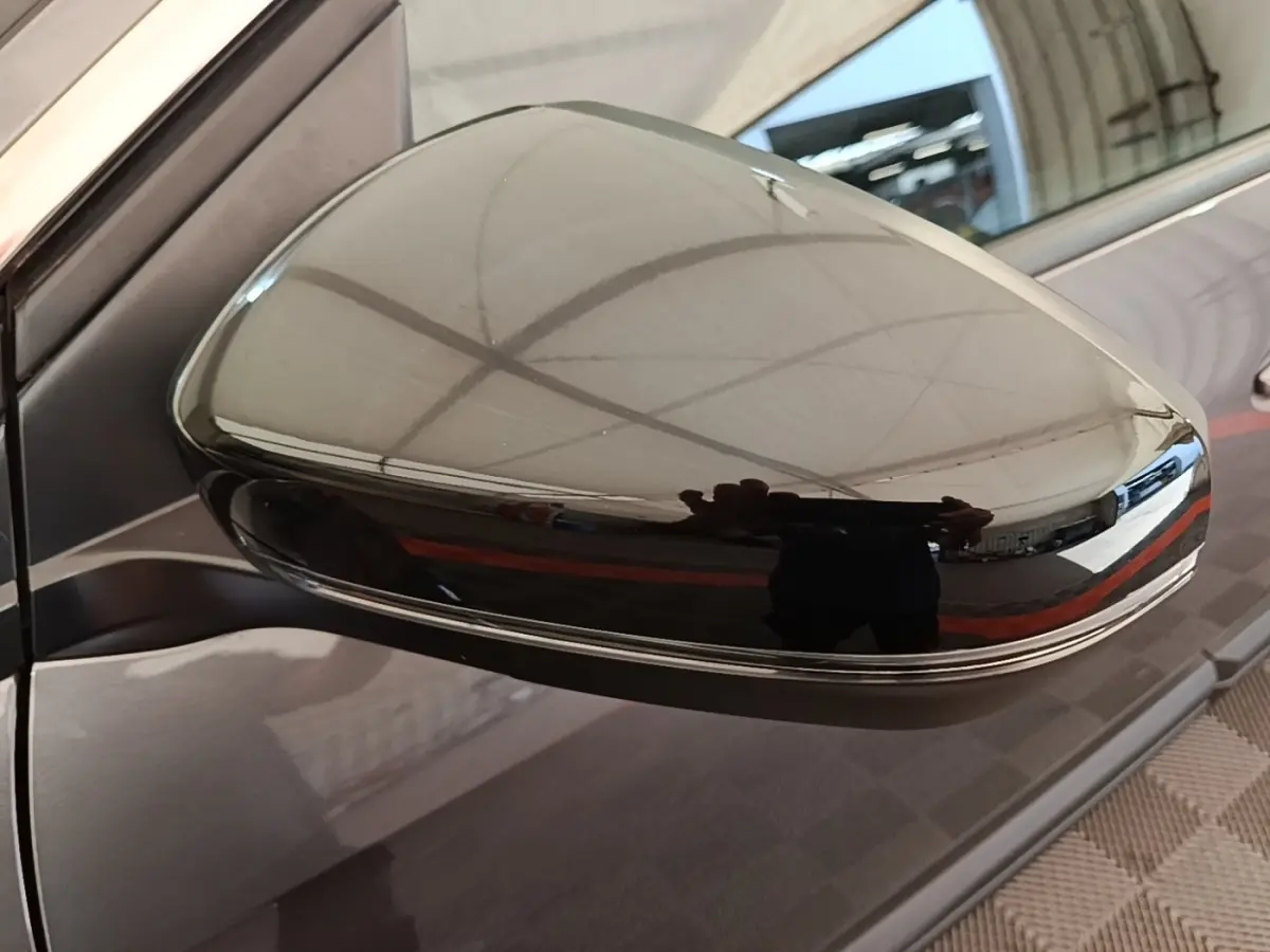 Gros plan sur le rétroviseur droit gris foncé brillant du Peugeot 3008, reflet d’un espace intérieur.