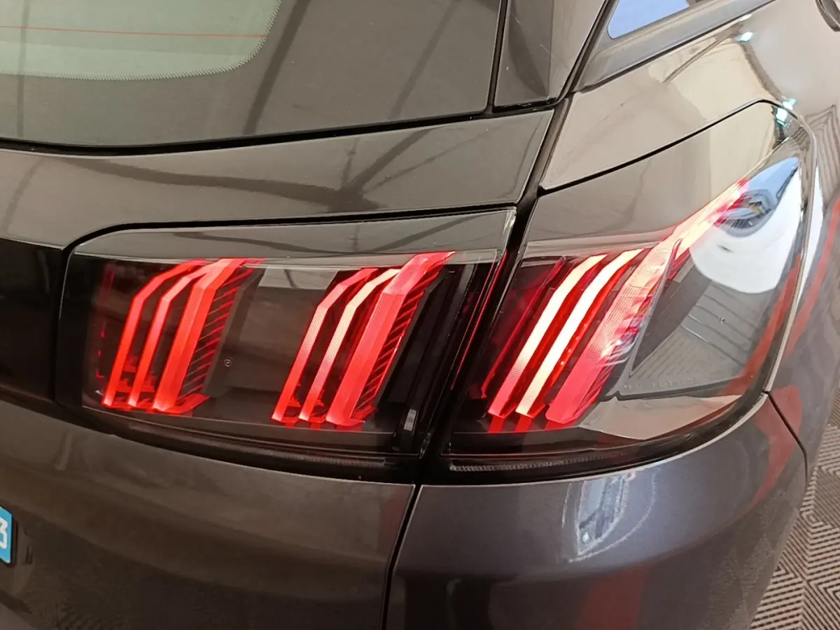 Gros plan sur le feu arrière droit rouge du Peugeot 3008 gris foncé, mettant en valeur ses lignes LED distinctives.