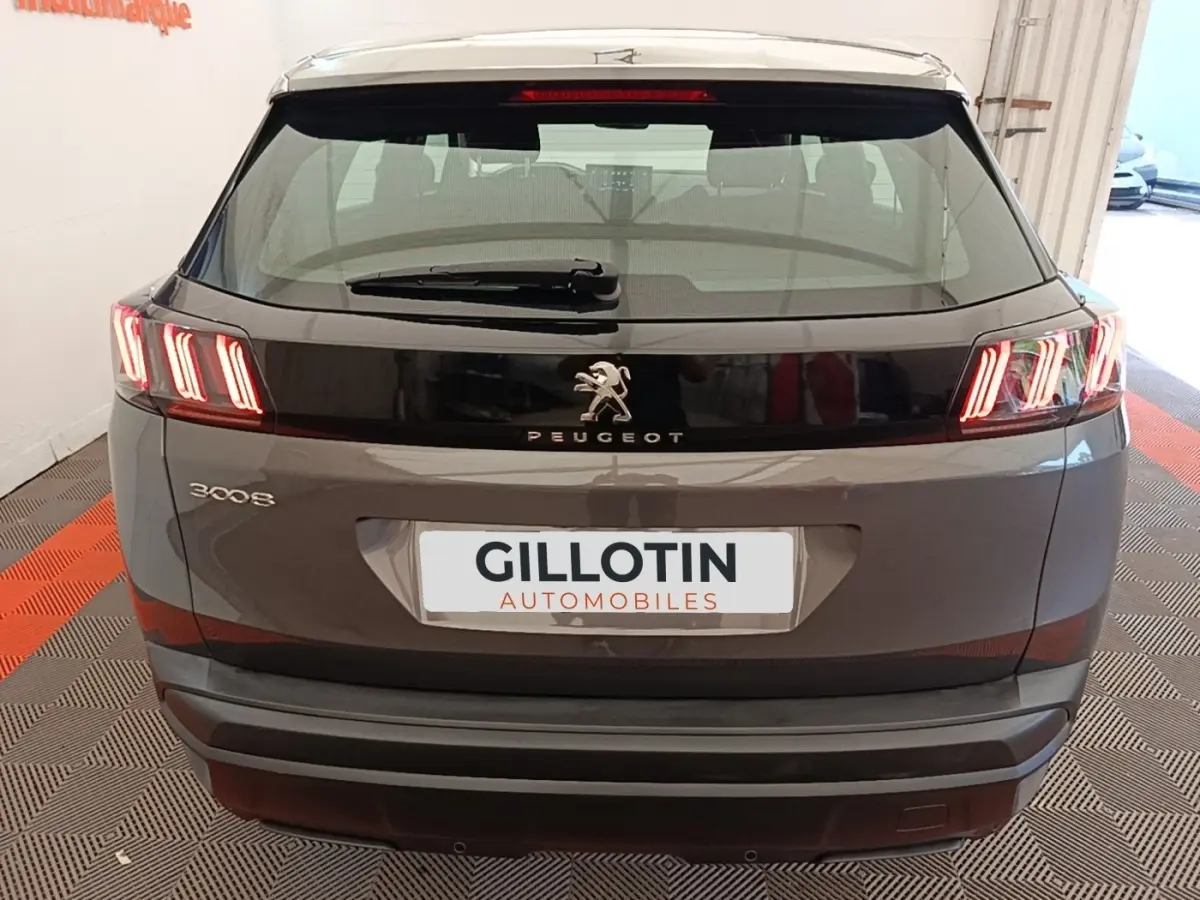 Vue arrière d’un Peugeot 3008 gris foncé avec feux arrière LED caractéristiques et logo central brillant.