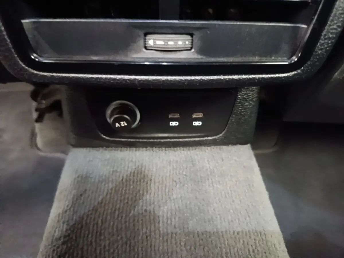 Vue rapprochée des prises USB-C et prise 12V noires sur la console centrale de l'Audi Q3 hybride rechargeable 2023.