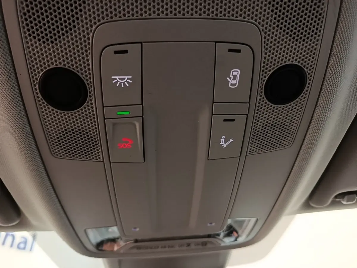 Vue en plongée sur le panneau de commandes au plafond de l'Audi Q3 45 TFSI e avec bouton SOS rouge allumé.