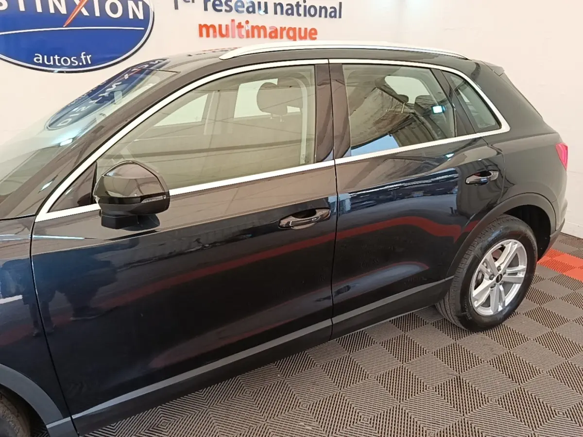 Vue de profil côté gauche d’un Audi Q3 hybride rechargeable 2023 noir avec jantes alliage et rétroviseurs noirs.