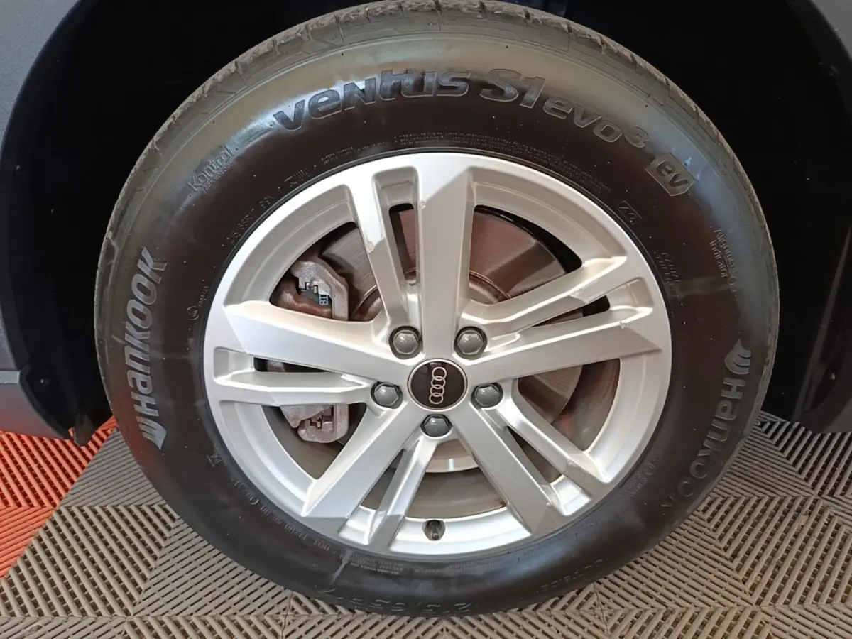Gros plan sur la roue avant droite d’un Audi Q3 45 TFSI e avec jante argentée et pneu Hankook noir.