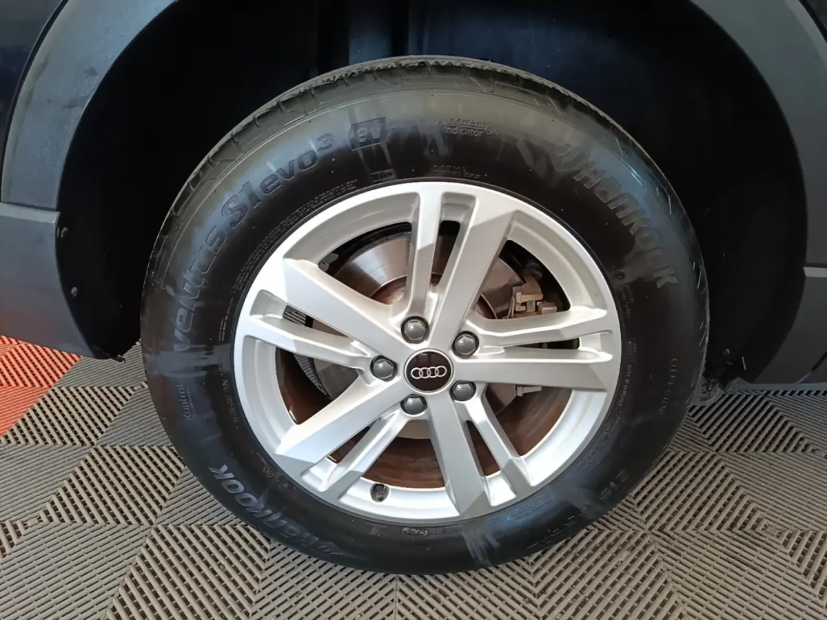 Gros plan sur la roue avant droite d’un Audi Q3 45 TFSI e avec jante argentée et pneu Hankook noir.