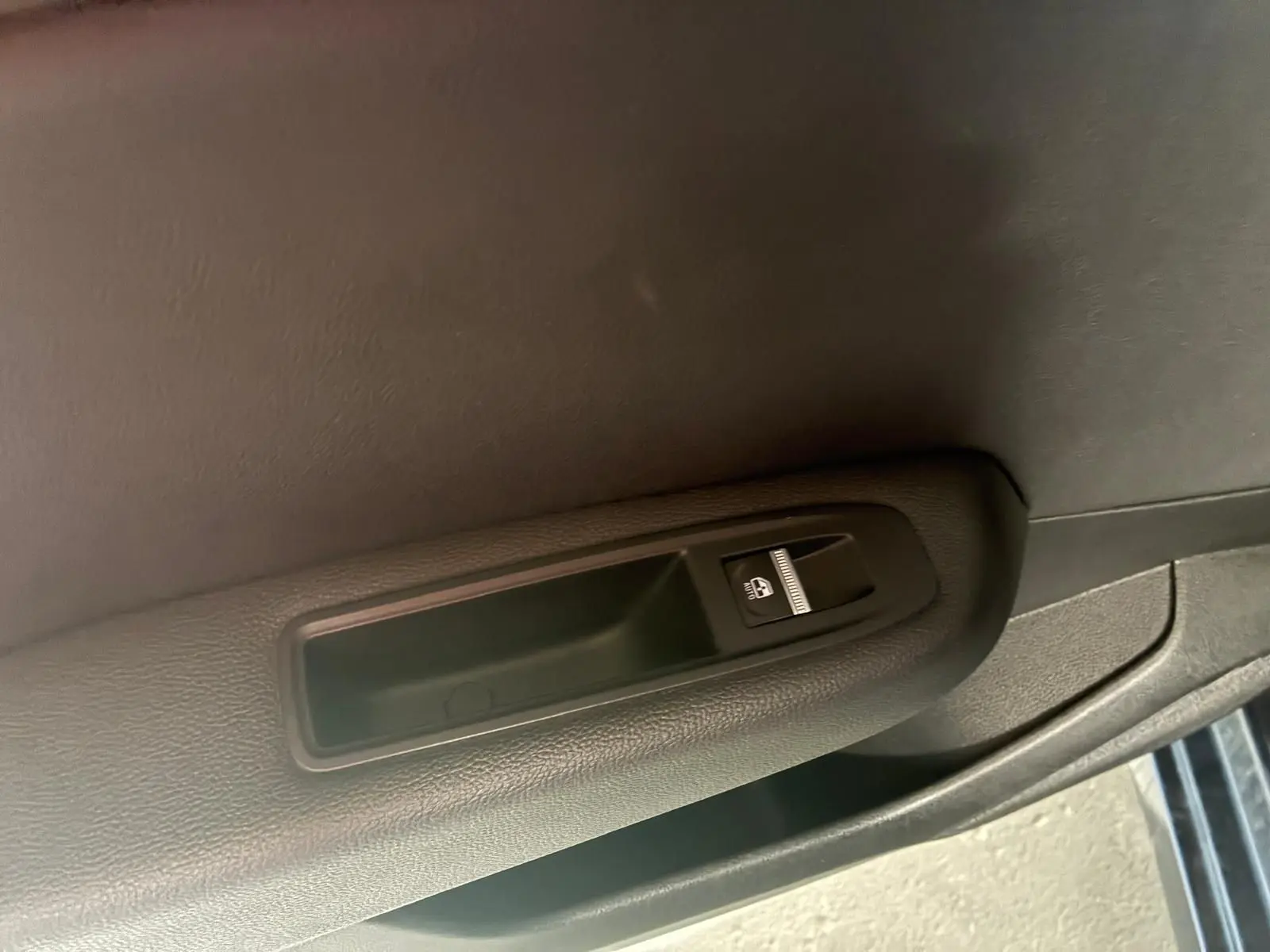 Bouton de commande de lève-vitre sur la portière intérieure côté droit d'une Renault Clio gris 2020.