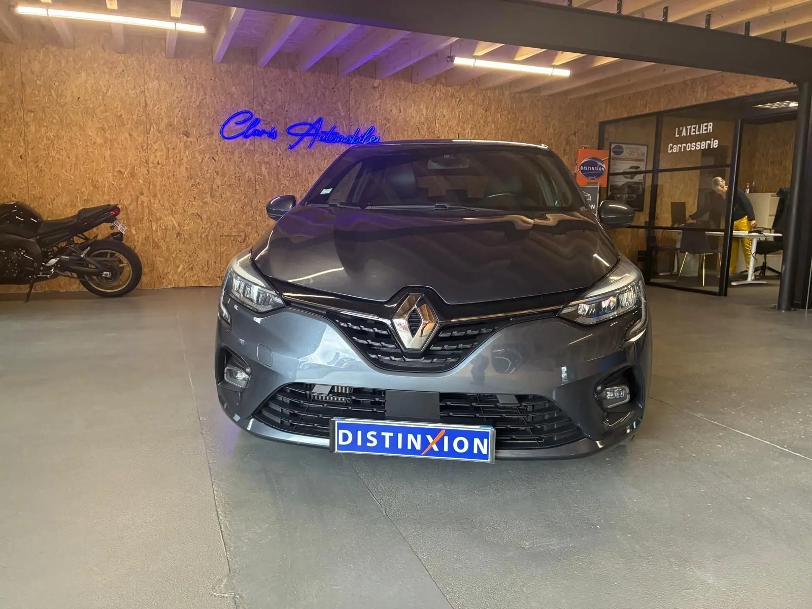 Vue frontale d'une Renault Clio gris métallisé 2020, avec calandre noire et logo Renault bien visible.
