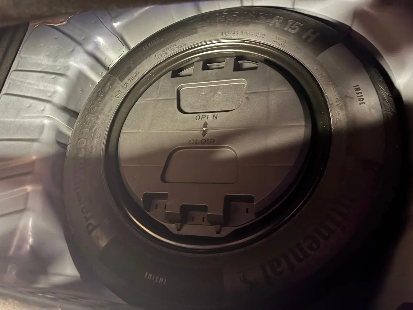 Gros plan sur la roue de secours dans le coffre d'une Renault Clio gris 2020, montrant le pneu Continental et son boîtier central.