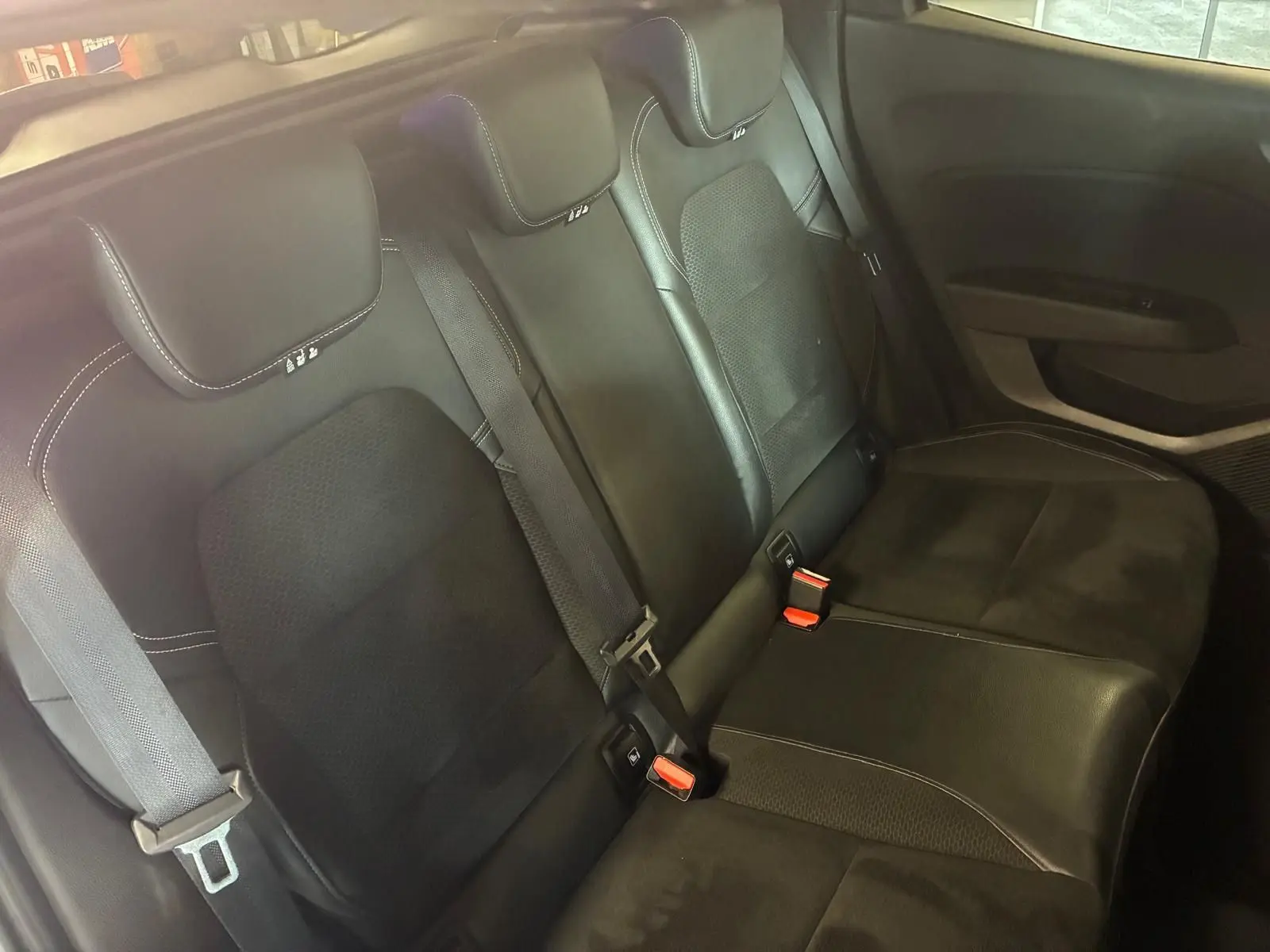Vue rapprochée des sièges arrière en tissu gris noir de la Renault Clio 1.0 TCE 100 Intens 2020, avec ceintures de sécurité visibles.