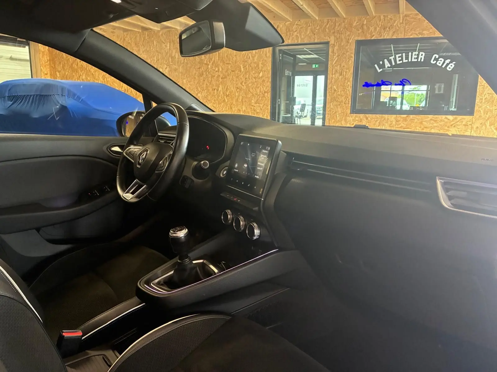 Intérieur de la Renault Clio 2020 gris, vue côté conducteur, volant multifonction et boîte manuelle visible.