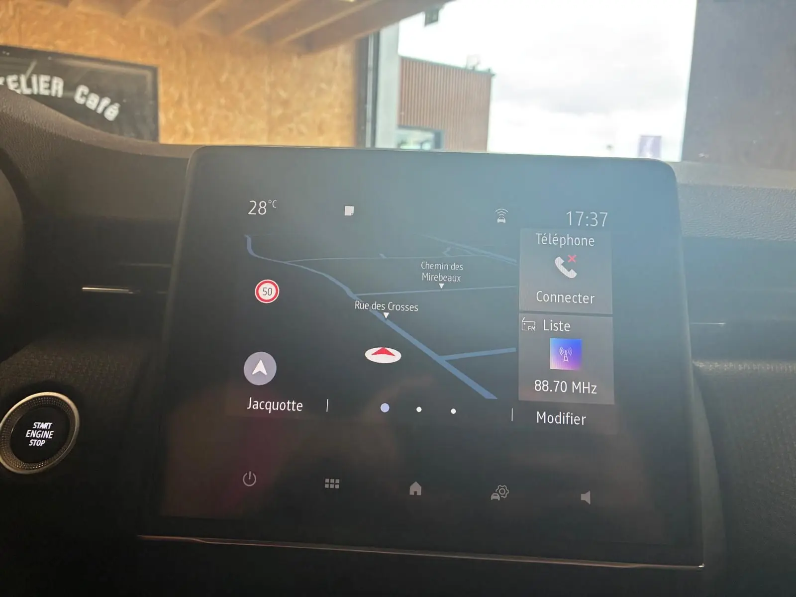 Écran tactile central du tableau de bord de la Renault Clio gris, affichant la navigation et la radio à 17h37.