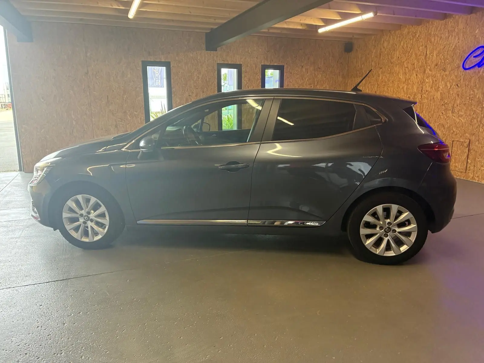Profil côté gauche d'une Renault Clio gris métallisé 2020, compacte cinq portes avec jantes alliage et vitres teintées.