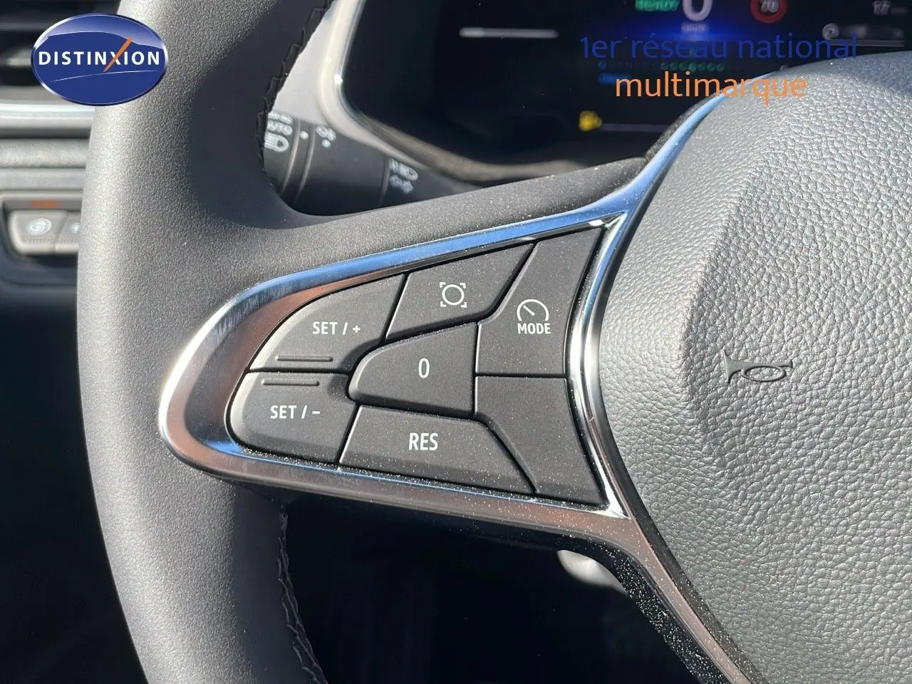 Gros plan sur les commandes du volant à gauche du Renault Captur noir étoile métal avec toit gris, version hybride 2025.