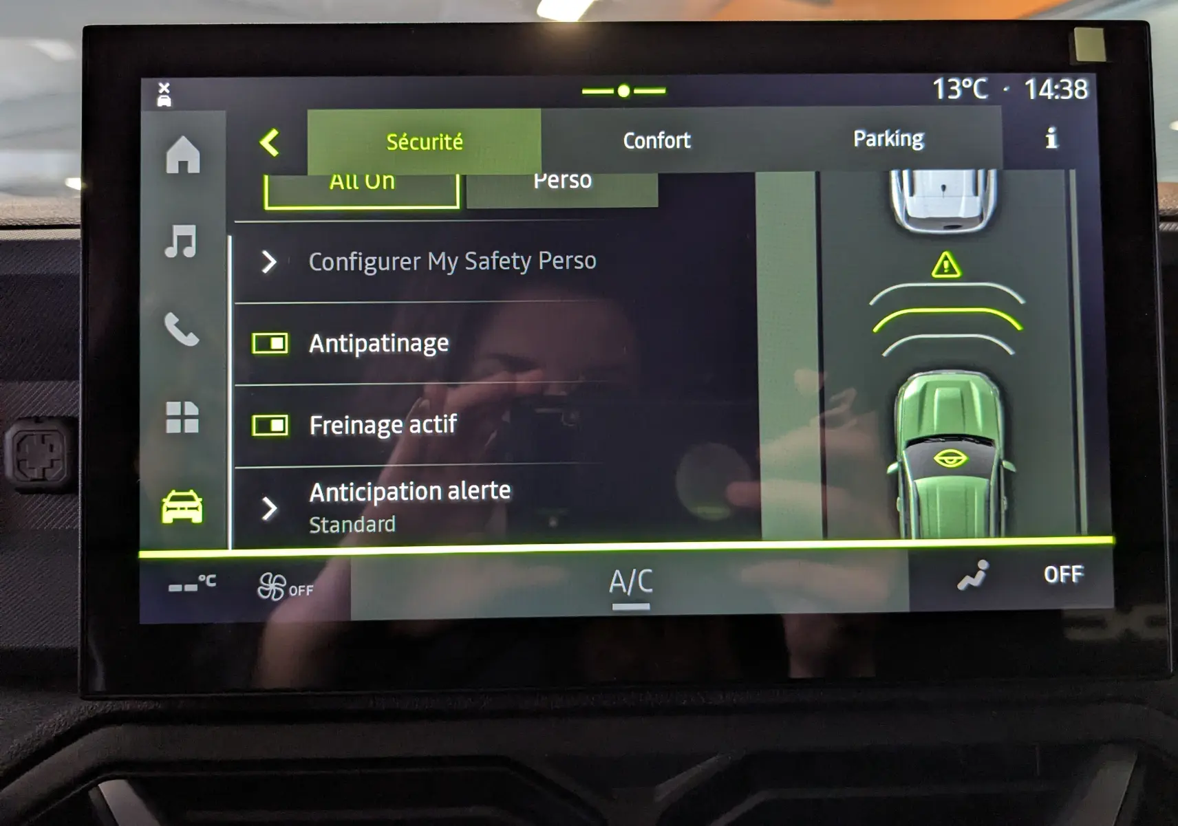 Écran tactile du tableau de bord du Dacia Duster Hybrid 140 Journey montrant les réglages de sécurité et assistance au stationnement.