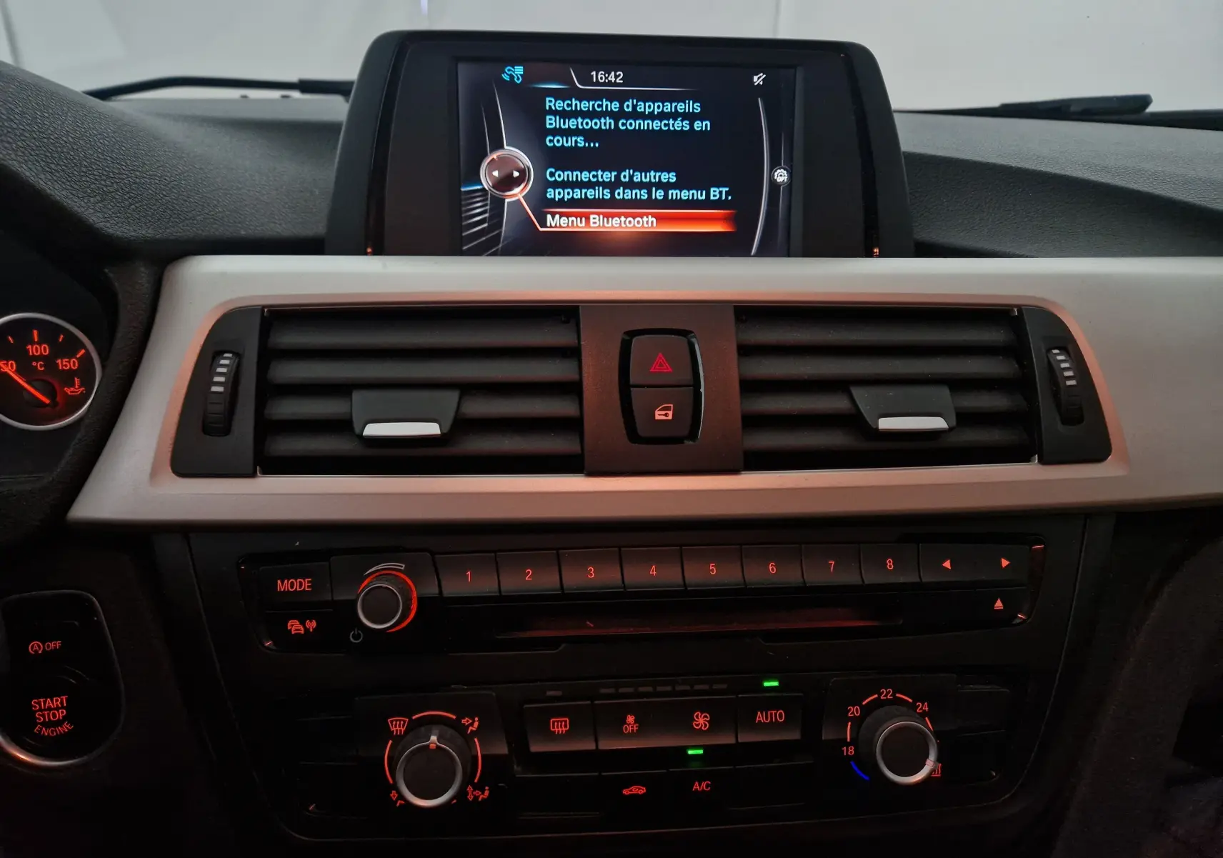 Tableau de bord intérieur d'une BMW Série 3 316D 2014, avec écran central affichant la recherche Bluetooth et commandes climatisation rétroéclairées.