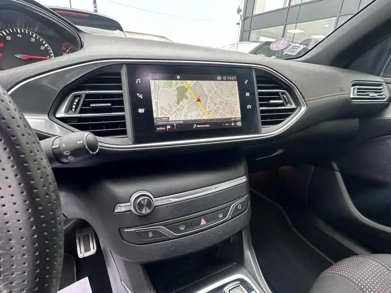 Intérieur de la Peugeot 308 gris métal 2019, vue du tableau de bord côté conducteur avec écran tactile affichant la navigation.