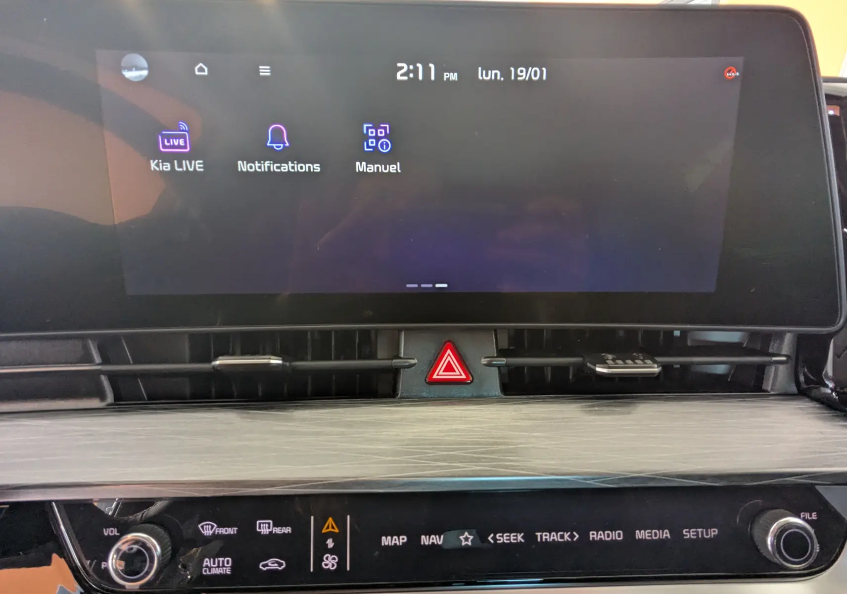 Écran tactile 12,3’’ du système de navigation Kia avec commandes multimédia et bouton de signalisation au centre.