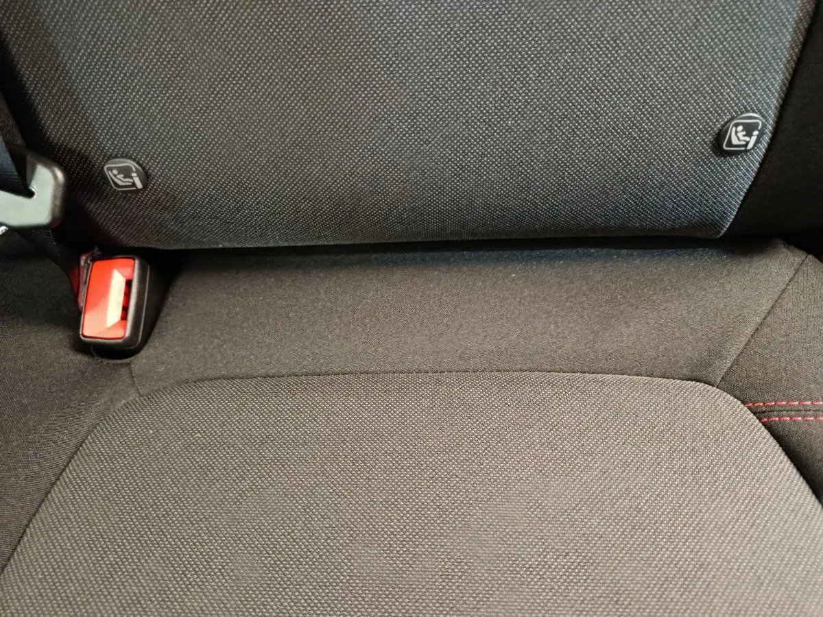 Gros plan sur la banquette arrière noire du Ford Puma 2025 avec fixation Isofix et boucle de ceinture rouge visible.