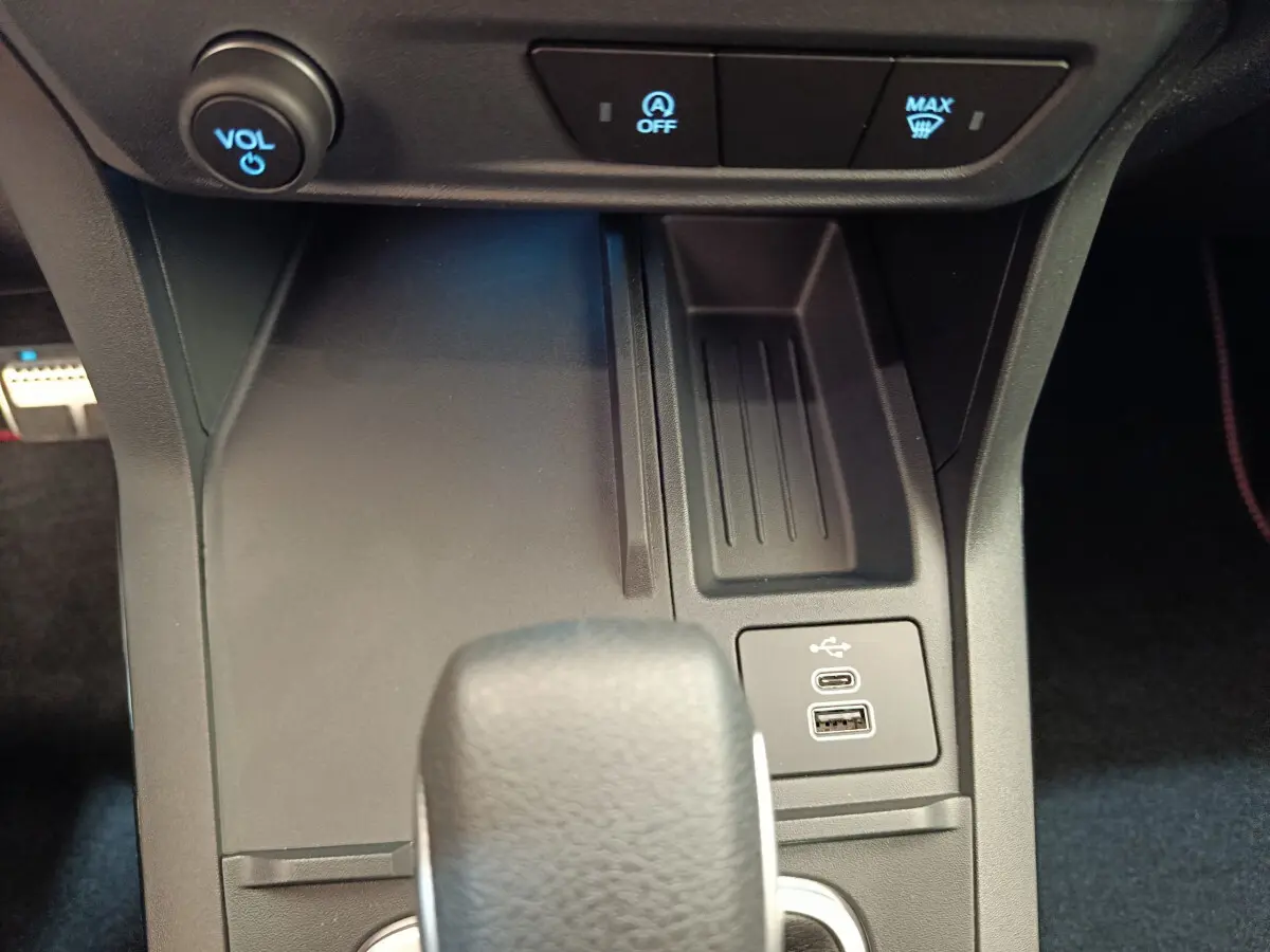 Gros plan sur la console centrale de la Ford Puma 2025, montrant la commande volume, boutons et ports USB.