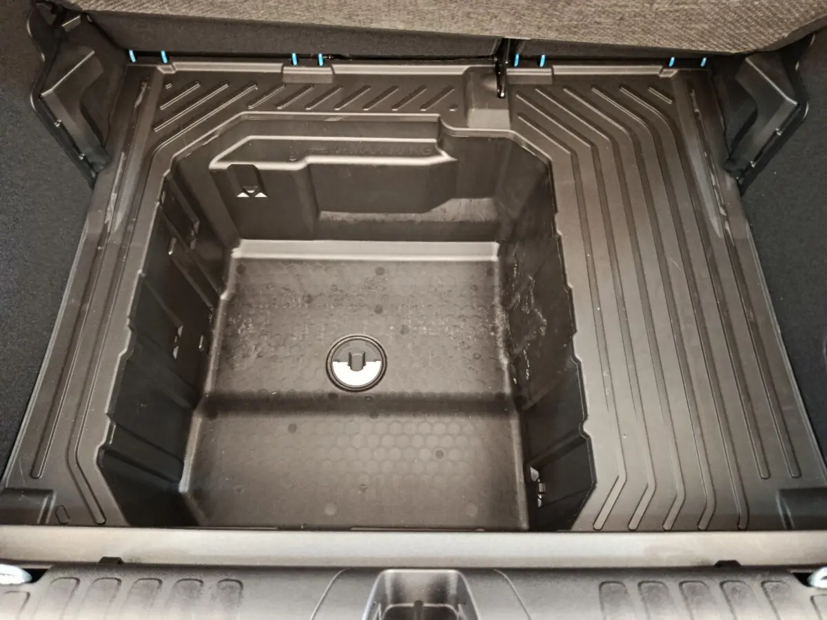 Coffre ouvert en vue plongeante du Ford Puma bleu 2025, montrant le compartiment de rangement sous tablette.