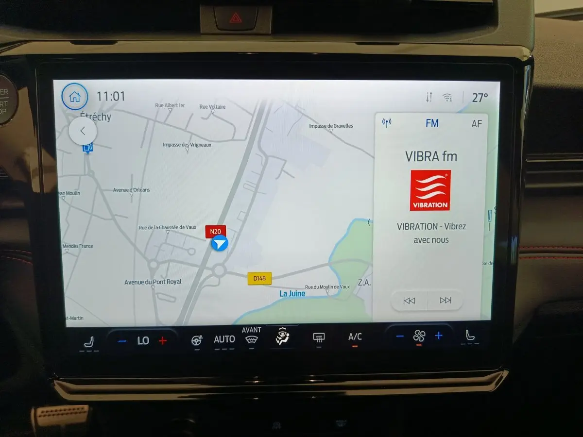 Écran tactile central du tableau de bord du Ford Puma 2025 affichant la navigation et la radio FM VIBRA fm.