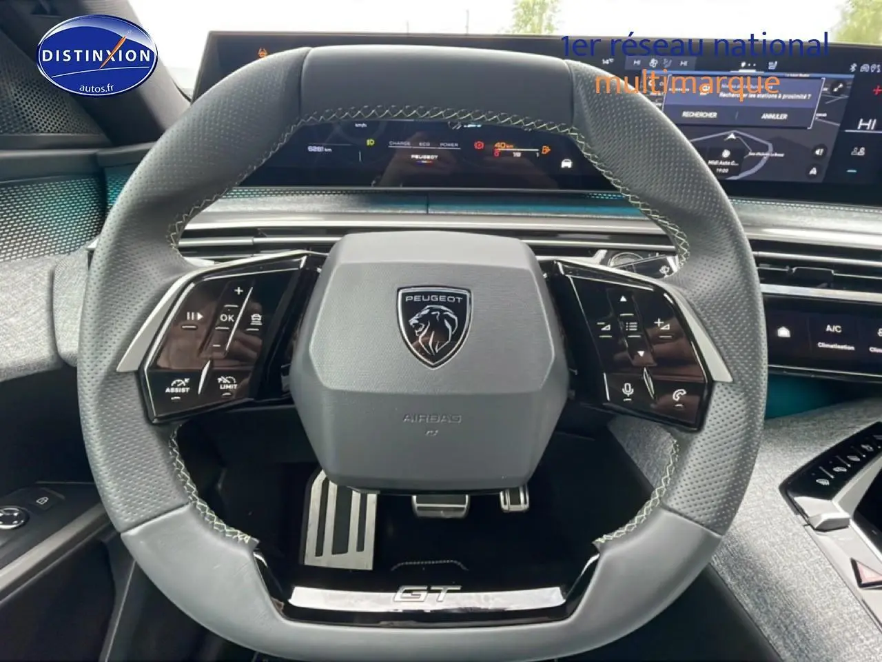 Vue rapprochée du volant cuir multifonction gris avec logo Peugeot et inscription GT sur un Peugeot 3008 blanc 2025.