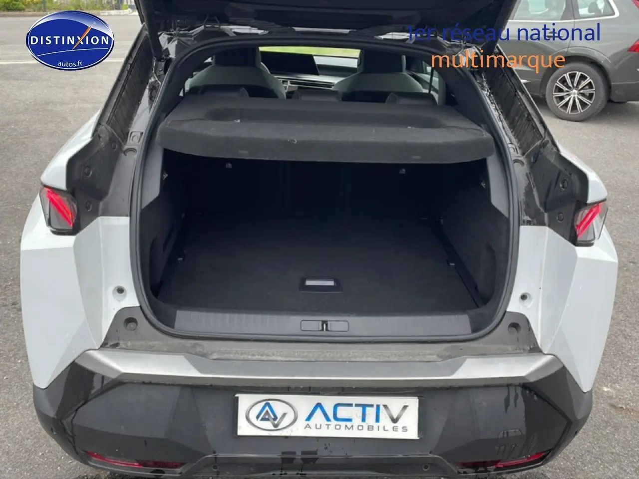 Coffre ouvert d’un Peugeot 3008 blanc vu de l’arrière, avec feux arrière LED et hayon noir contrasté.