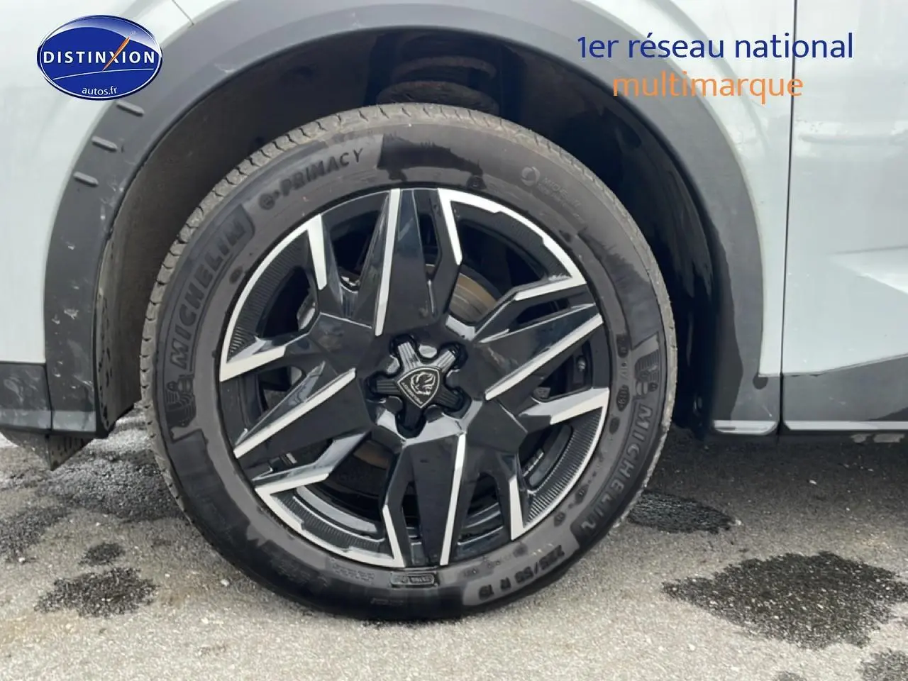 Gros plan sur la roue avant droite du Peugeot 3008 blanc, mettant en valeur la jante alu noire et argentée au design moderne.