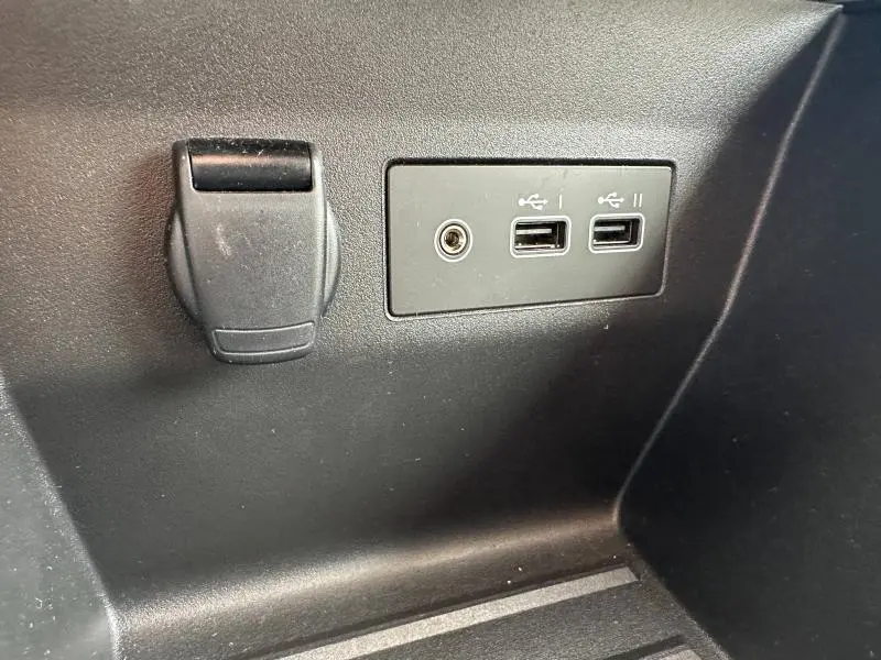 Détail intérieur montrant deux ports USB et une prise 12V sur fond noir dans une Renault Clio 2025.