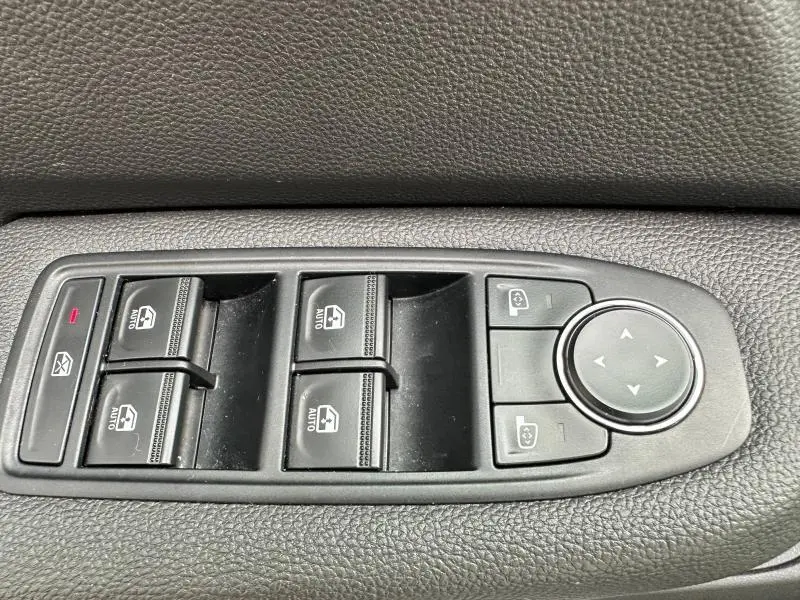 Commande des vitres électriques et réglage des rétroviseurs sur la porte intérieure noire d'une Renault Clio 2025.