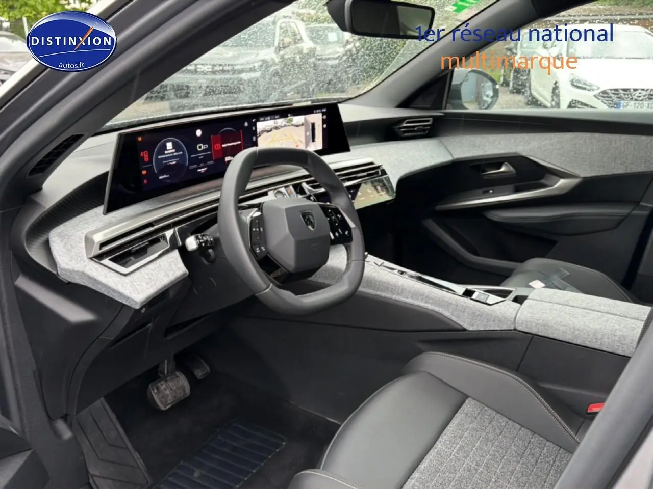 Vue intérieure côté conducteur du Peugeot 5008 Hybrid 145 allure e-dcs6 2025 avec tableau de bord numérique et sellerie gris clair.