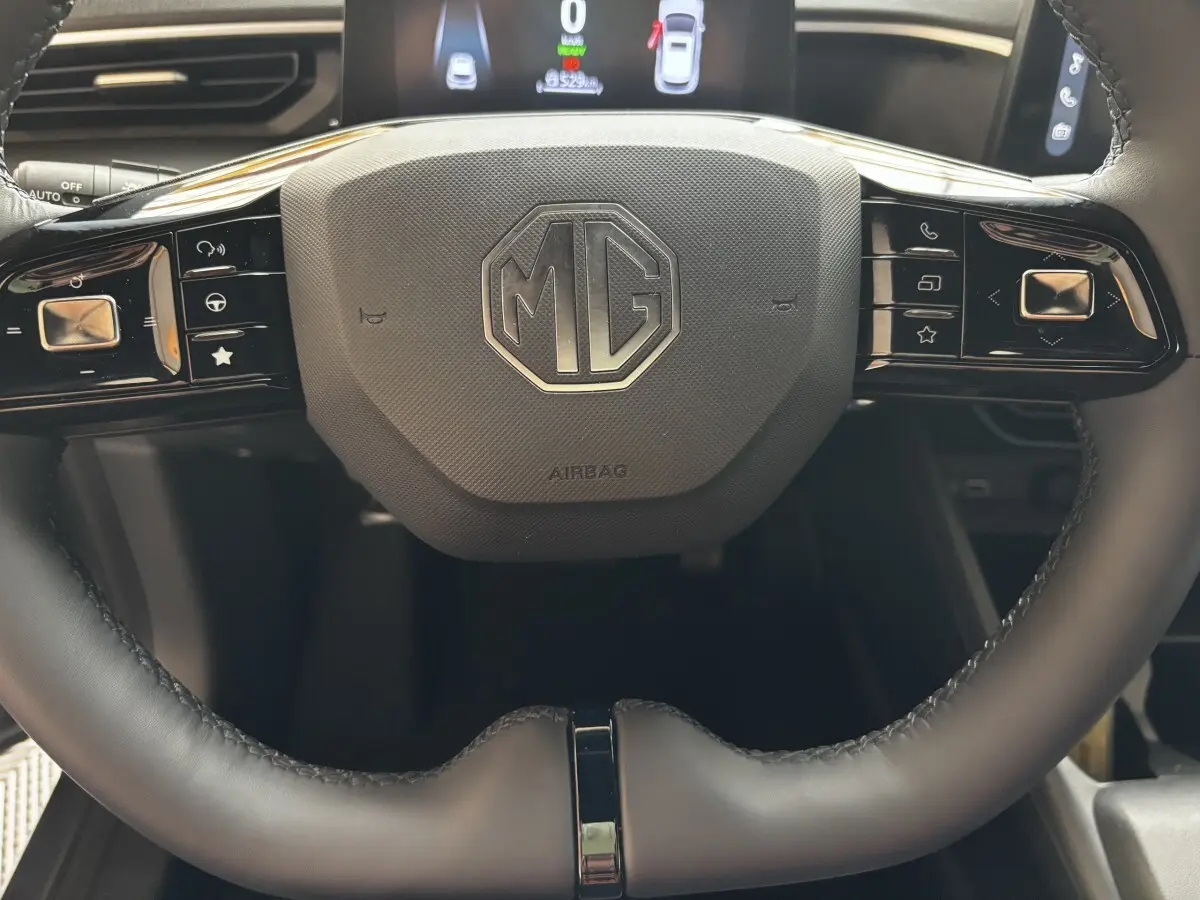 Gros plan sur le volant en suède noir du MG3 1.5L 195ch Hybrid+ Luxury avec commandes multifonctions intégrées.
