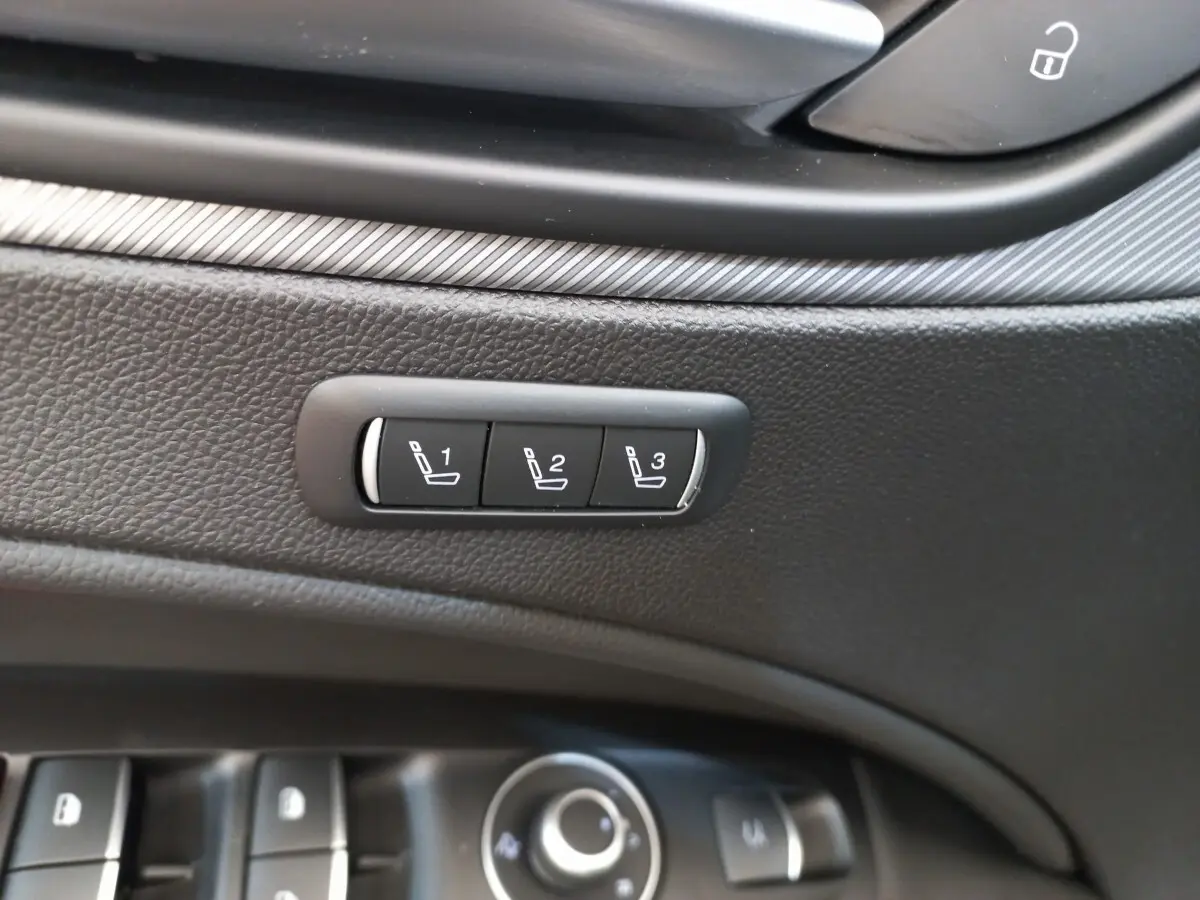 Détail des commandes de mémorisation des sièges sur la porte intérieure noire d'une Alfa Romeo Stelvio gris foncé.