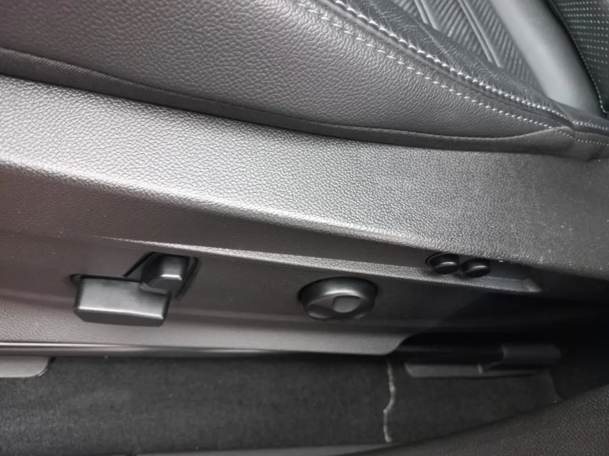 Détail des commandes de réglage du siège en cuir noir de l'Alfa Romeo Stelvio 2024, côté gauche.