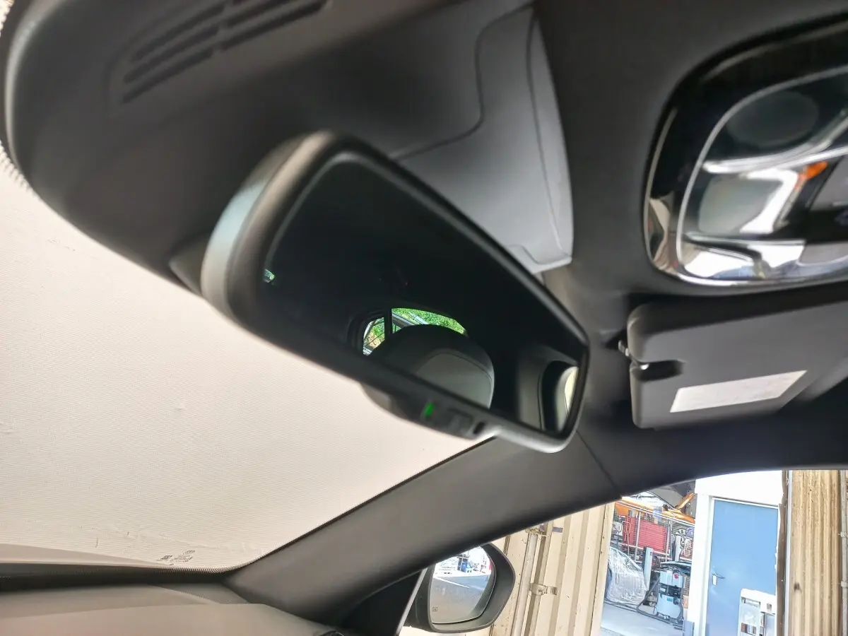 Rétroviseur intérieur et pare-soleil côté conducteur de l'Alfa Romeo Stelvio gris foncé, vue depuis l'habitacle.