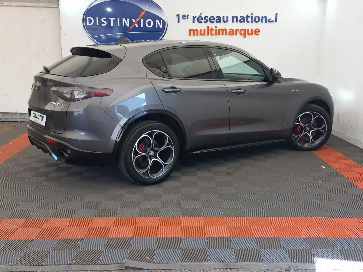 Vue 3/4 arrière droite de l'Alfa Romeo Stelvio gris foncé avec jantes sport distinctives et feux arrière LED.