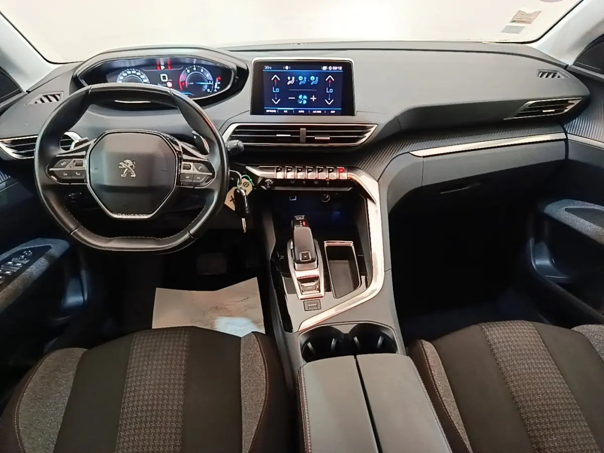 Intérieur Peugeot 3008 noir, vue frontale du poste de conduite avec volant cuir et écran tactile central.