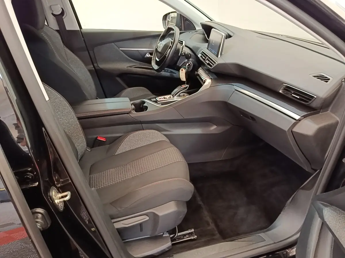 Vue intérieure côté conducteur du Peugeot 3008 noir, mettant en valeur le volant cuir multifonctions et l’écran tactile central.
