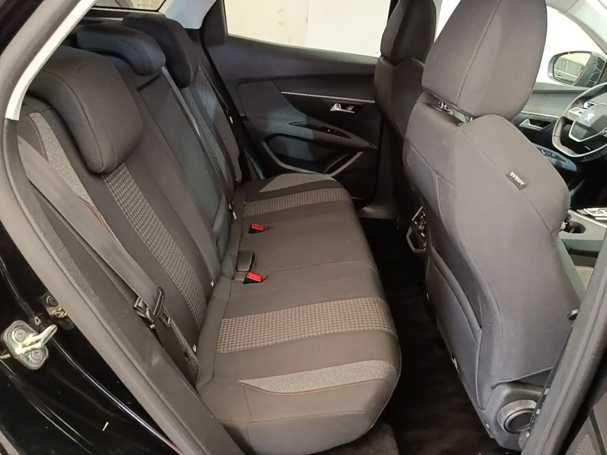 Vue intérieure côté gauche montrant la banquette arrière noire et les sièges avant du Peugeot 3008 noir de 2018.