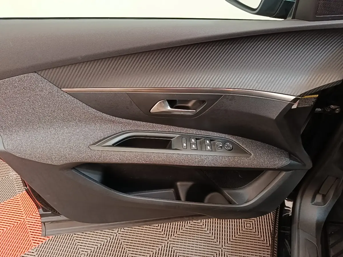 Vue intérieure du panneau de porte avant gauche du Peugeot 3008 noir, avec commandes des vitres et poignée intégrée.