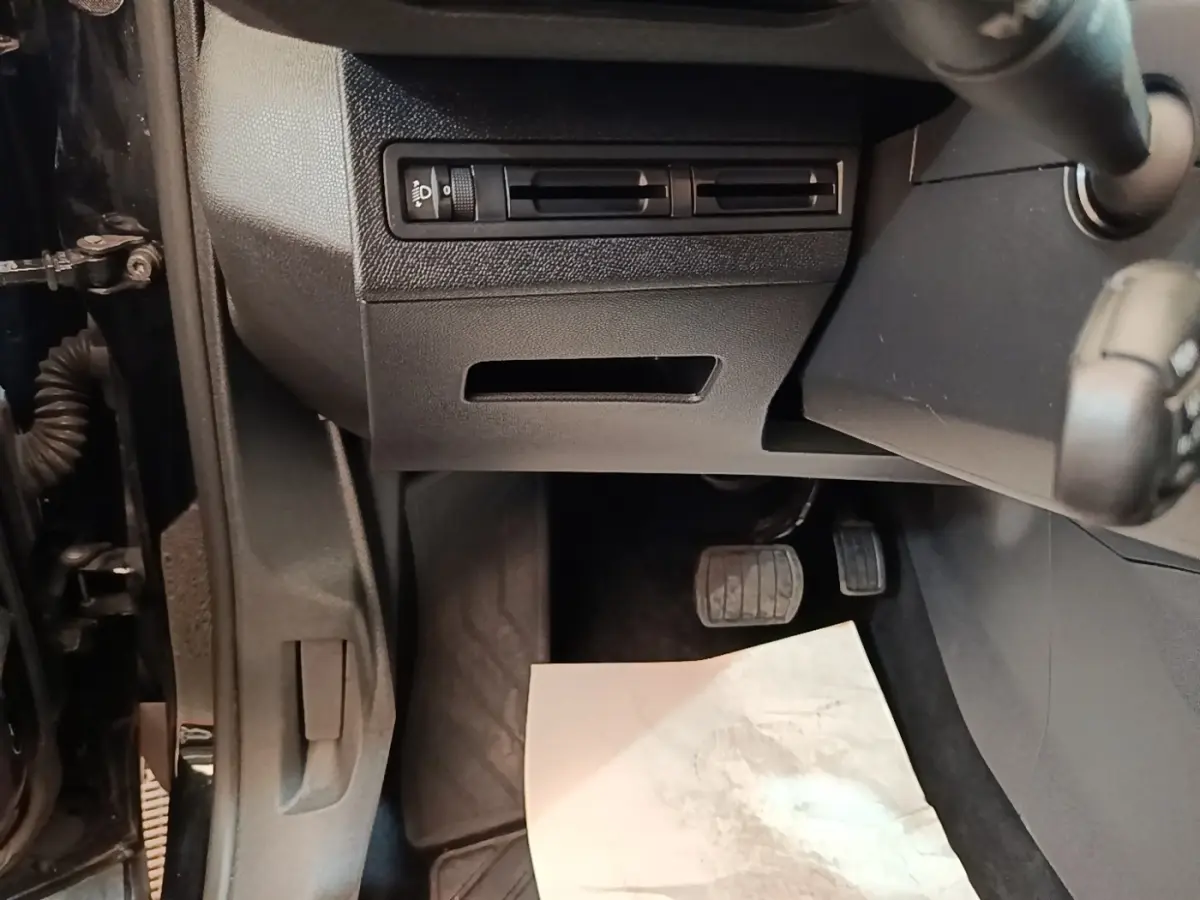 Vue intérieure côté conducteur du Peugeot 3008 noir, montrant la partie inférieure du tableau de bord et les pédales.