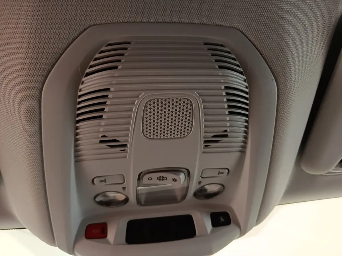 Vue en gros plan du plafonnier gris clair avec commandes d’éclairage et haut-parleur dans un Peugeot 3008 noir.
